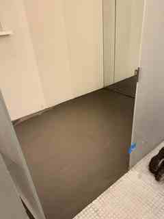 Smooth brown feather cement leveling coat on a commercial subfloor, before the finished floor.