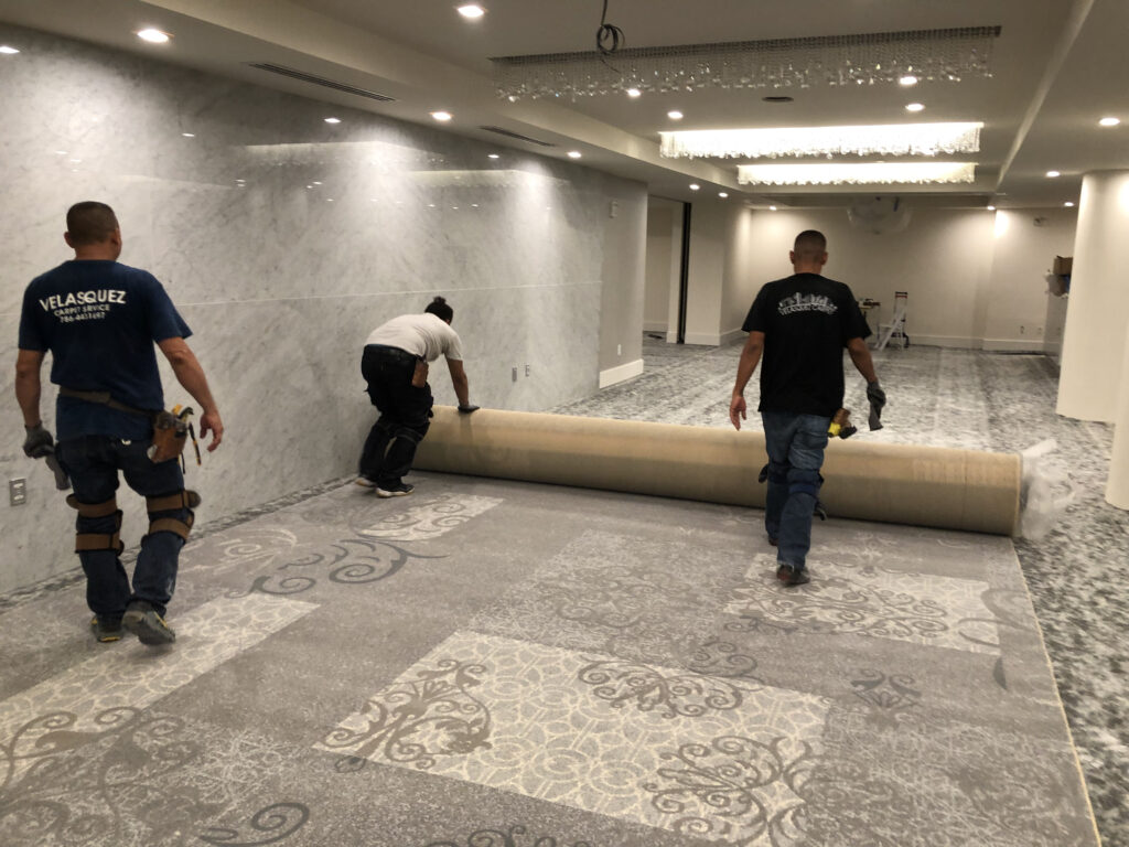 Velasquez Carpet crew rolling out new commercial carpet in a hotel