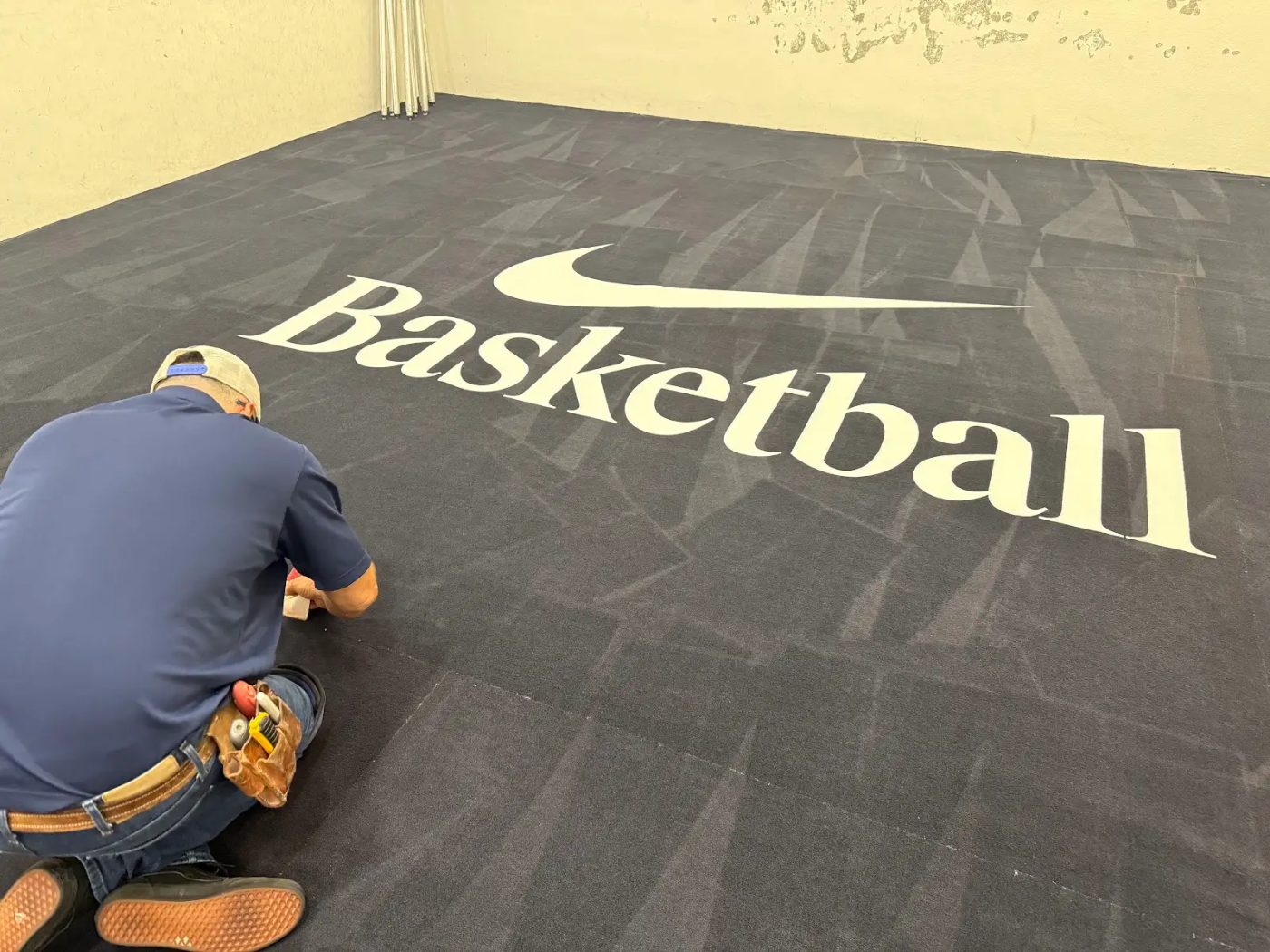 Installer fitting custom printed logo carpet for an event